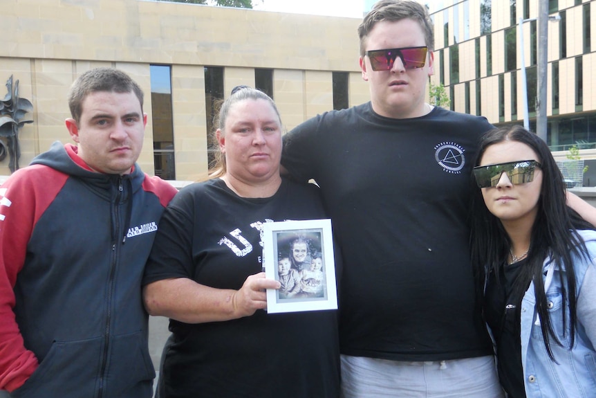 Jarrod Turner's family holding a framed photo of him.