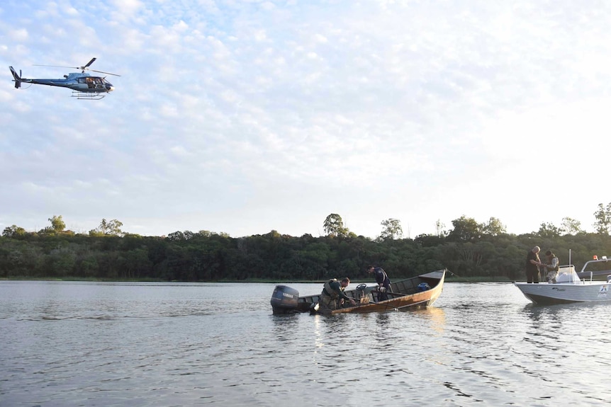 Police inspect a boat that assailants used to escape.