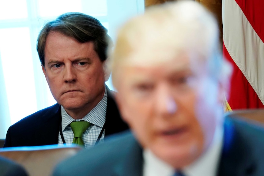 White House counsel Don McGahn sits behind Donald Trump.