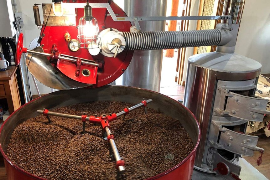 Cofee beans are being roasted in a bright red roasting machine which was owned by the Maloberti family.