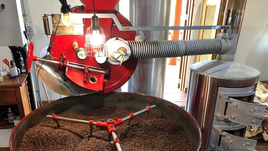 Cofee beans are being roasted in a bright red roasting machine which was owned by the Maloberti family.