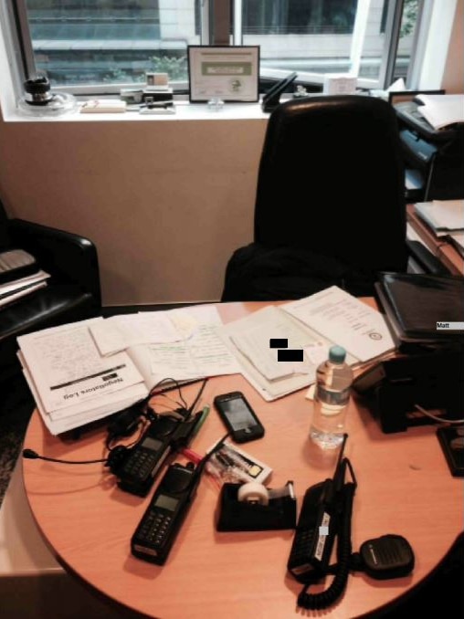 An office desk with papers and radios.