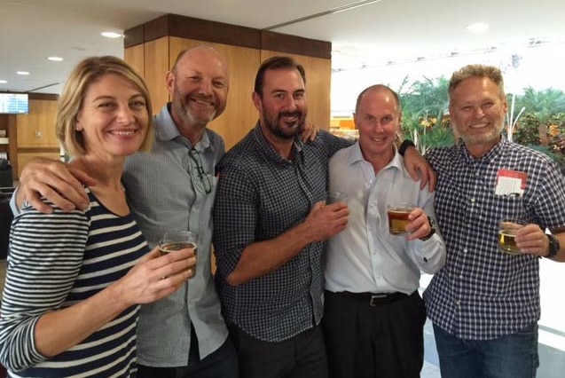 The 60 Minutes crew pose a photo in what looks to be a hotel foyer.