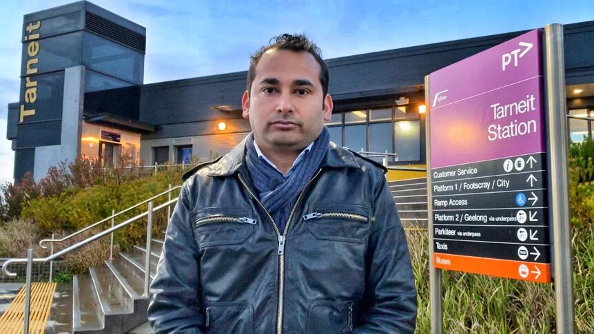 Arnav Sati, in a black jacket and scarf, stands at the front of the Tarneit V/Line train station.