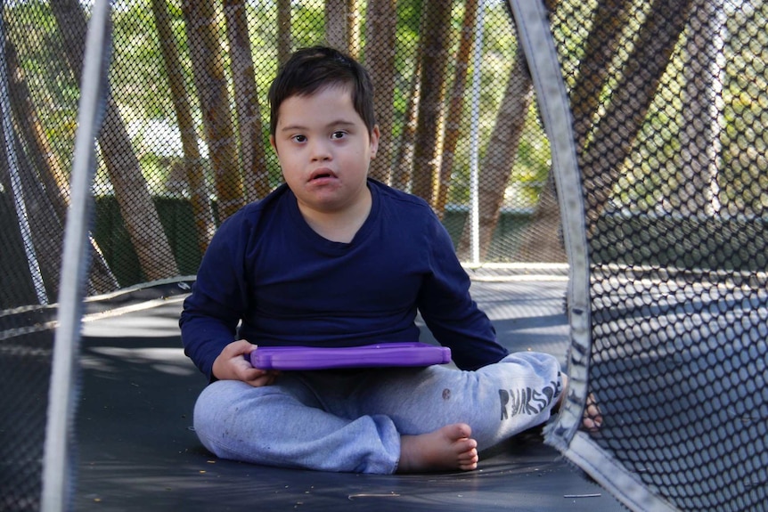 Victor Taschke sits on a trampoline.