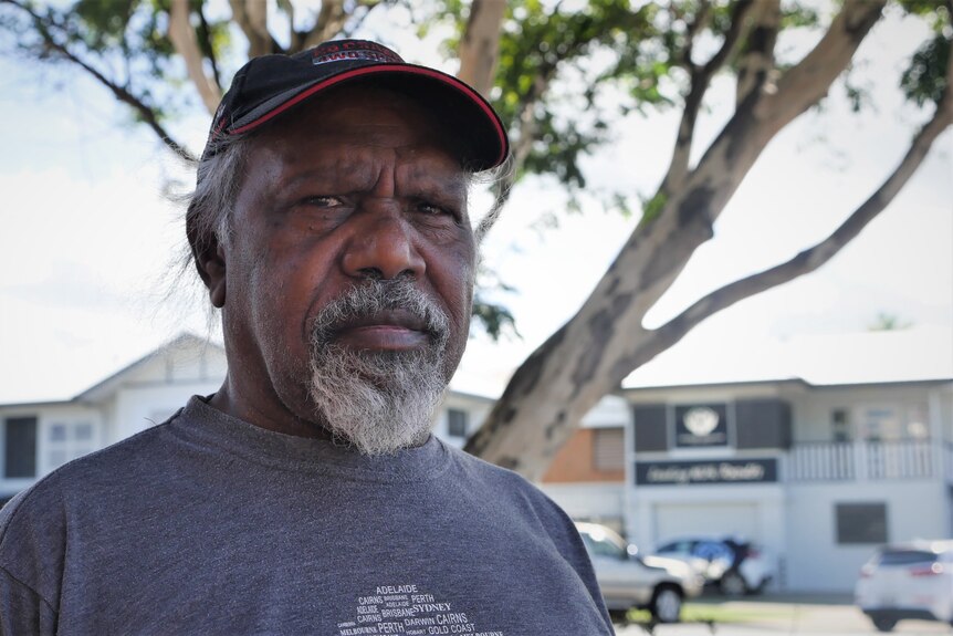 A portrait image of an Aboriginal man with a grey goatee and a black cap