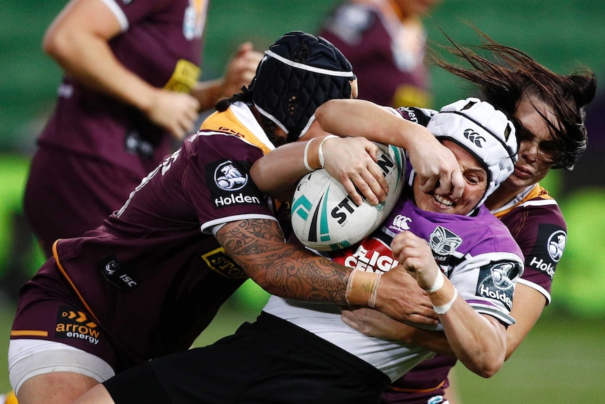 Lorina Papali'i of the Warriorsb being tackled by Amber Pilley and Rona Peters of the Broncos.