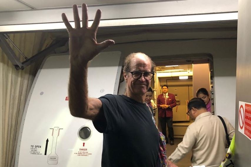 James Ricketson waves as boarding plane