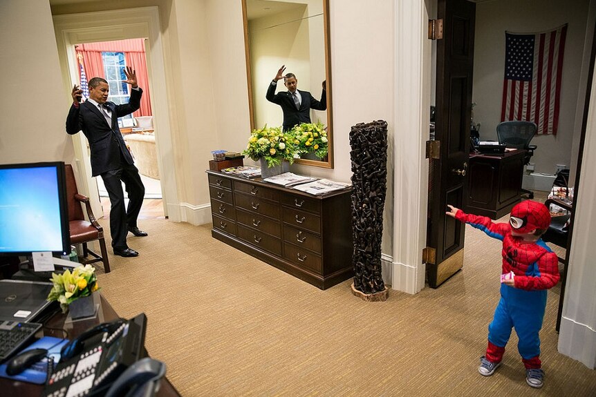 Barack Obama pretends to be caught in Spider-Man's web.