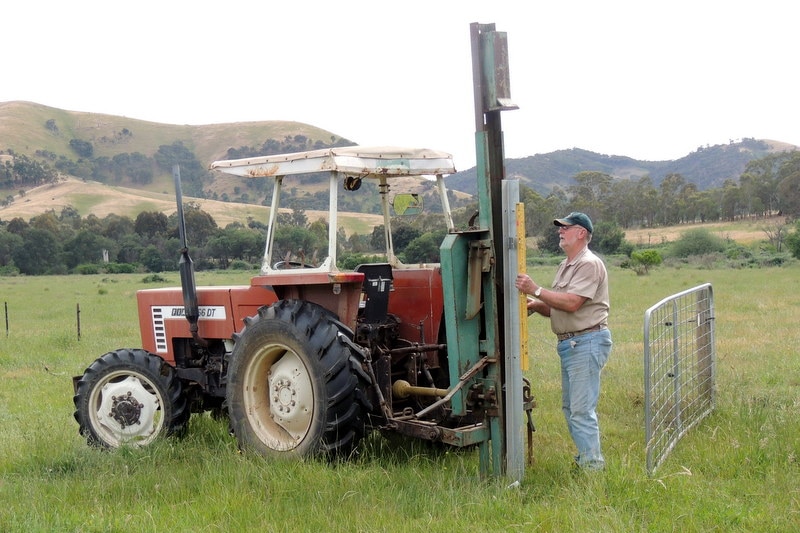 A Victorian farmer stands next to a tractor in the Flowerdale area.
