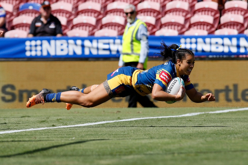 NRLW Eels player Tiana Penitani is horizontal and airborne, about to land and score a try