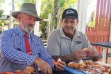 Bill Byrne (centre) eating prawns with Morgan's Seafood employees