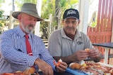 Bill Byrne (centre) eating prawns with Morgan's Seafood employees