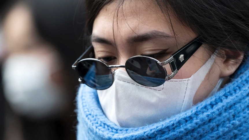 A woman wearing a mask crosses a road in the Shibuya district on February 02, 2020 in Tokyo, Japan.
