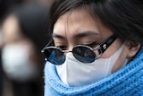 A woman wearing a mask crosses a road in the Shibuya district on February 02, 2020 in Tokyo, Japan.