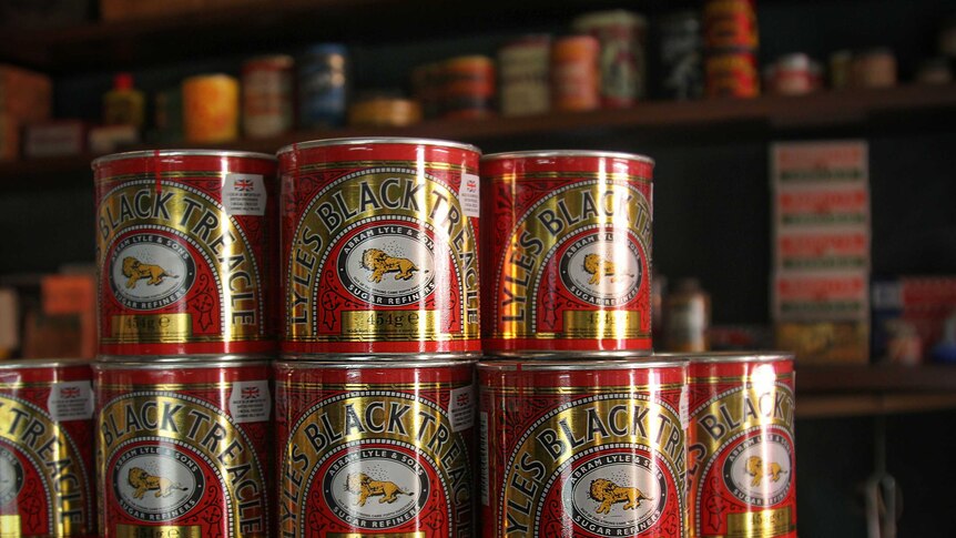 Tins of treacle stacked on top of one another.