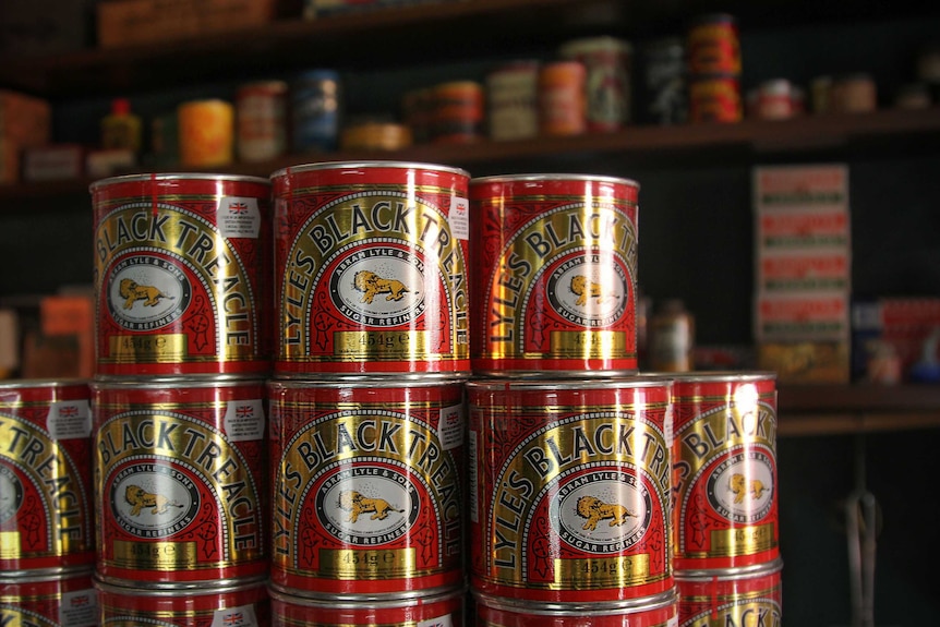 Tins of treacle stacked on top of one another.