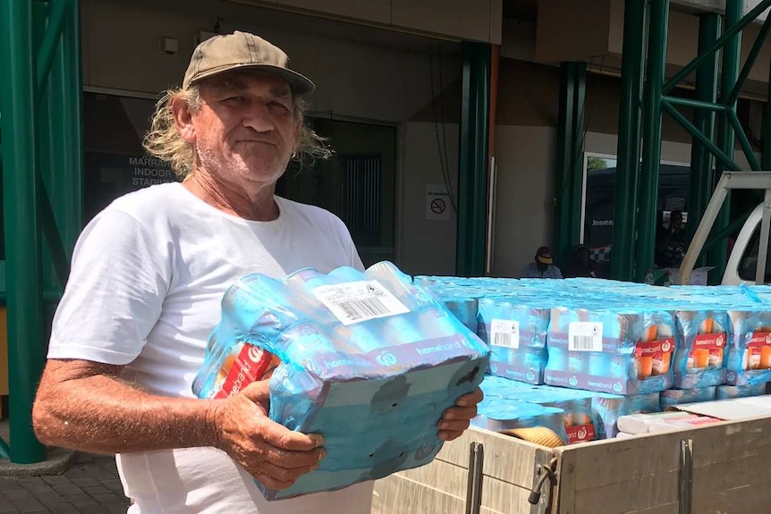 Broderick Crook stands with cans of baked beans.