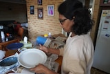 A side view of Dimuthu handling a plate in a kitchen