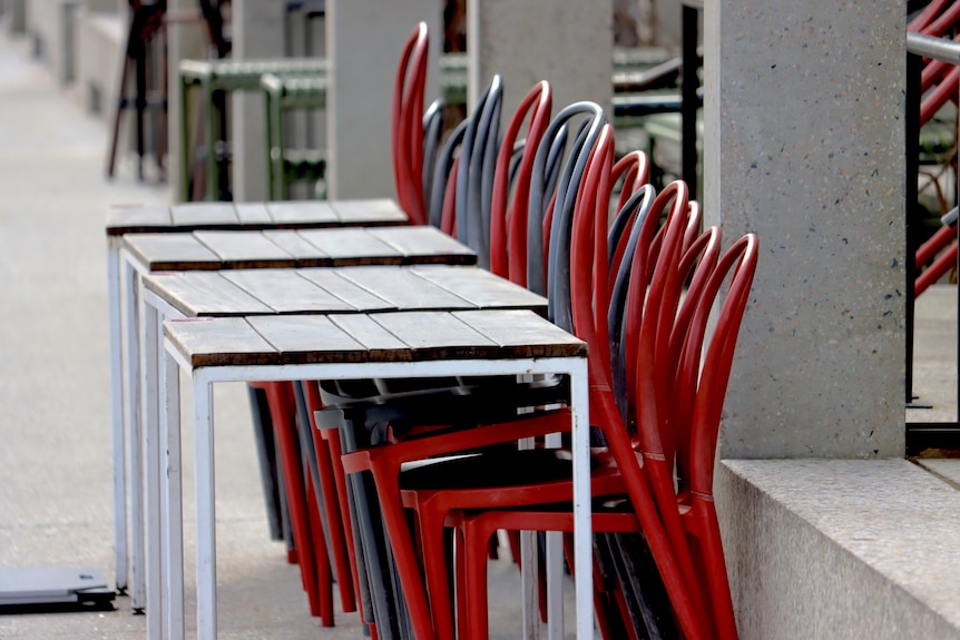 cafe seats stacked up high outside an empty cafe