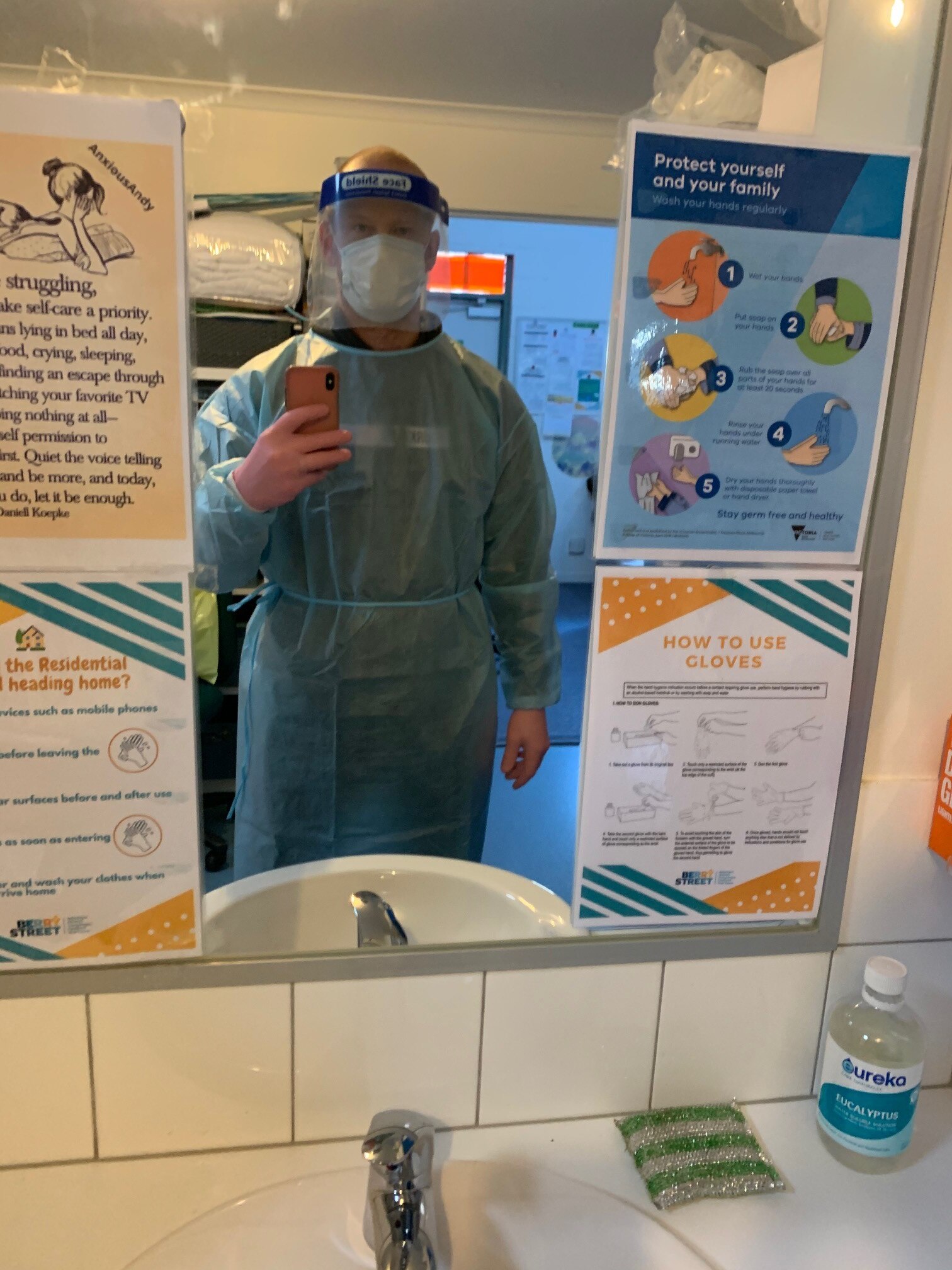 A man in full PPE taking a mirror selfie