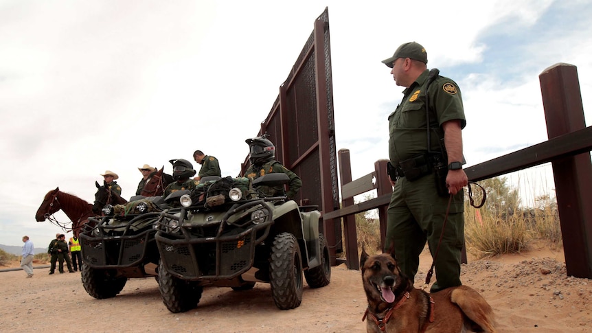 Border Patrol agents keep watch by the border wall