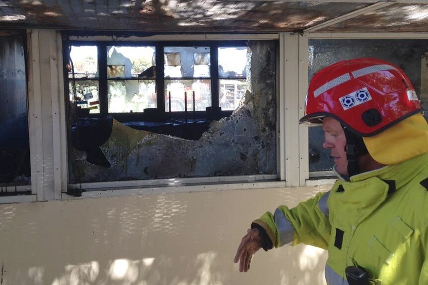 A fireman checks out the damage to Atwell classrooms in Perth