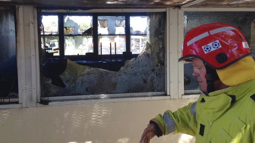 A fireman checks out the damage to Atwell classrooms in Perth