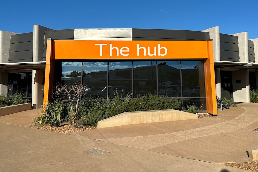 The outside of a modern single-storey building with an orange sign with the words 'the hub' on it