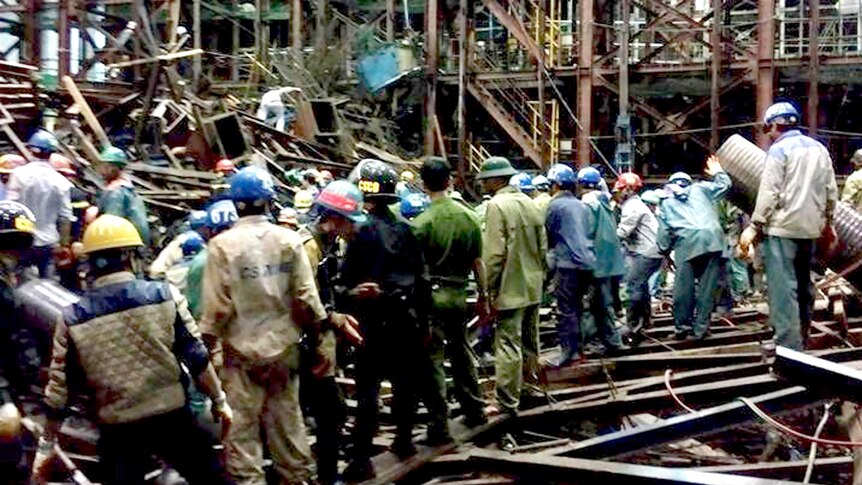 Workers and rescuers gather at the site of collapsed scaffolding
