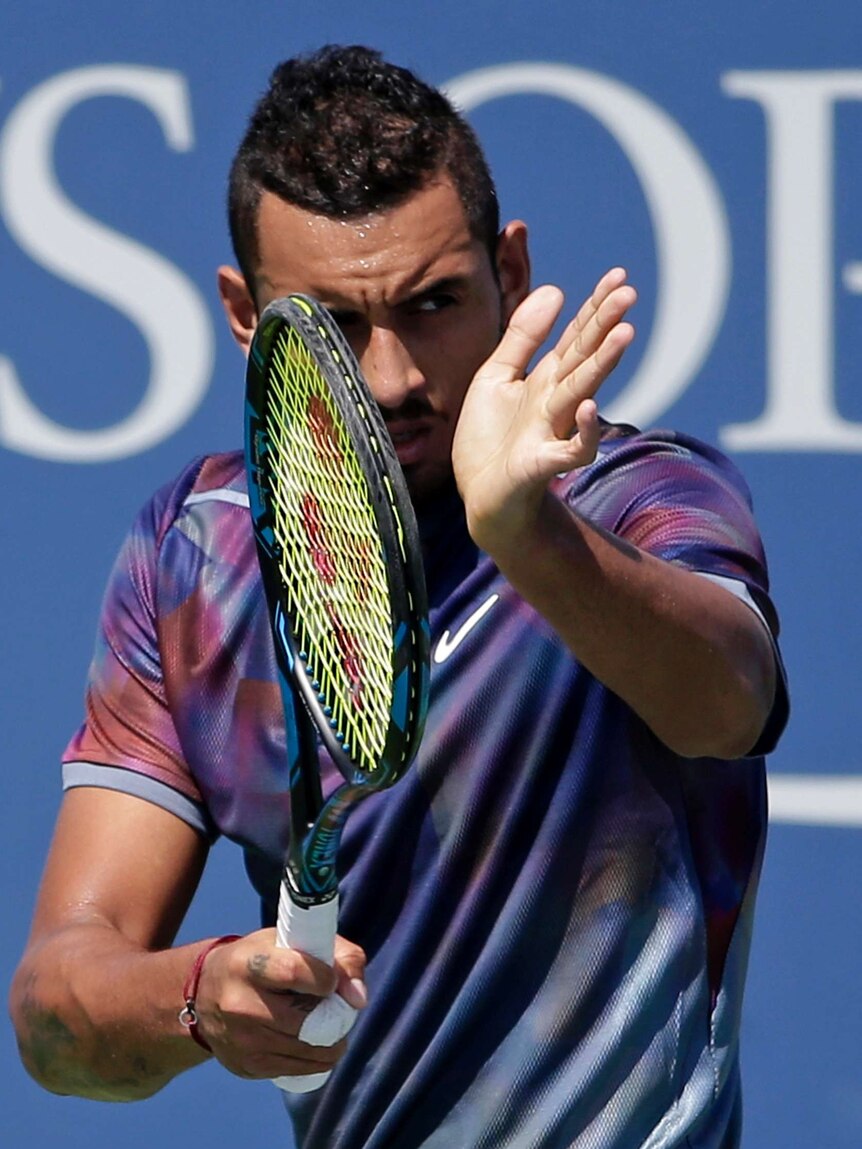 Nick Kyrgios applauds with his racquet.