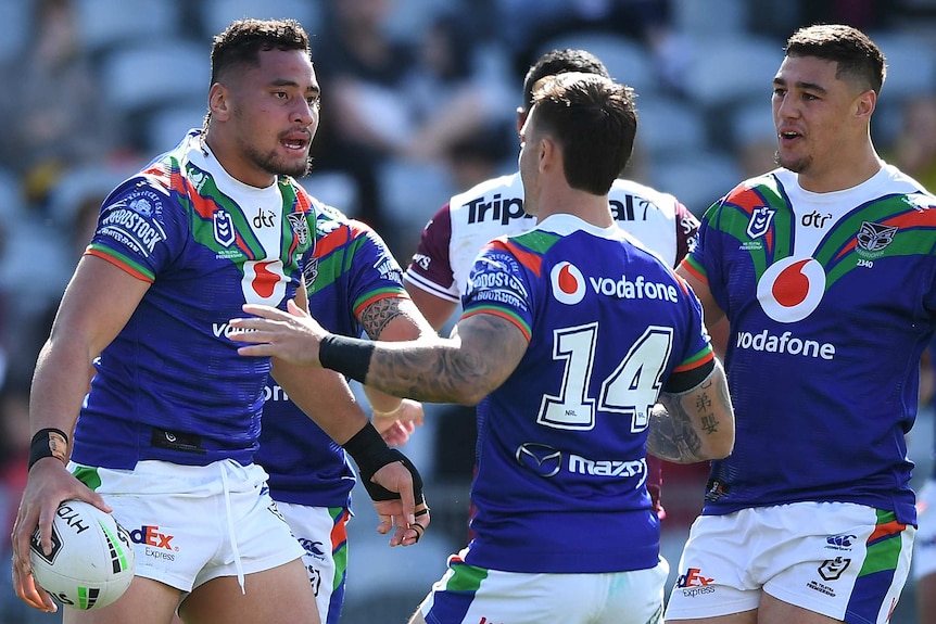 Three Warriors NRL players celebrate a try scored against Manly.