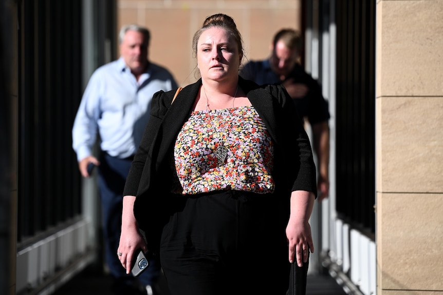 a young woman walking outdoors after leaving a court house