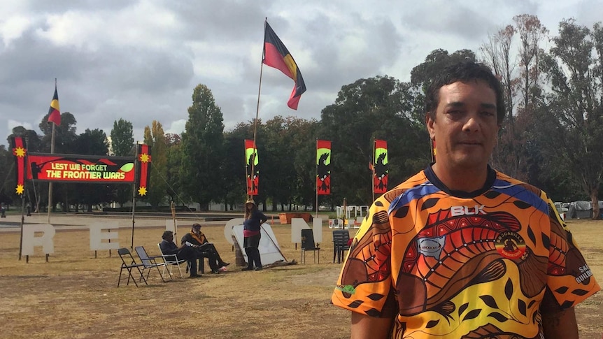 Rodney Kelly stands in front of the fire at the tent embassy in Canberra.