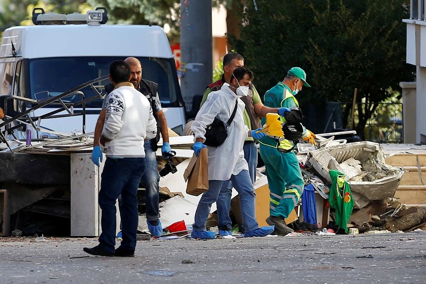 Police forensic experts examine a blast site