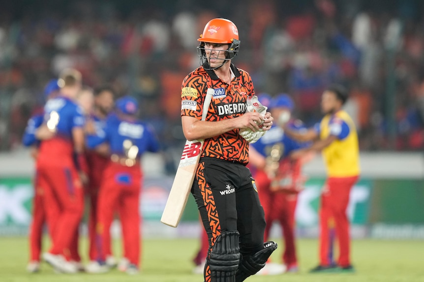 Pat Cummins walks off the field in an IPL game after being dismissed
