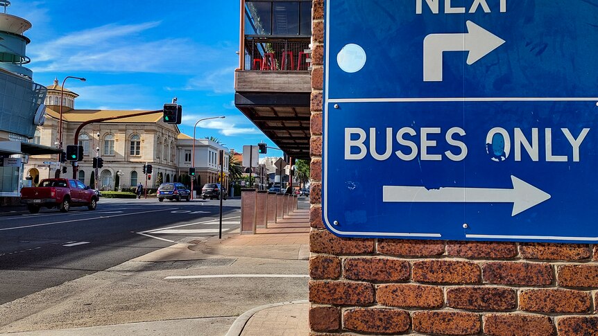 bus sign with buildings in background