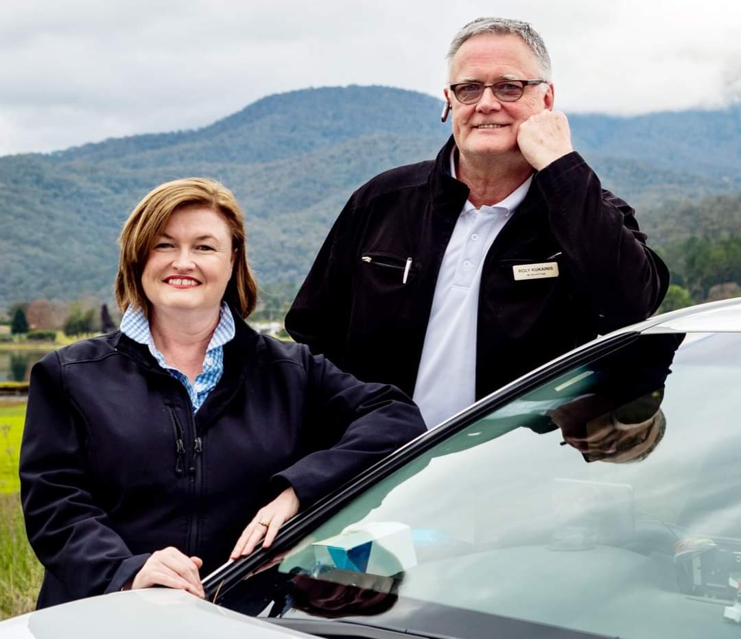 man and woman leaning on vehicle