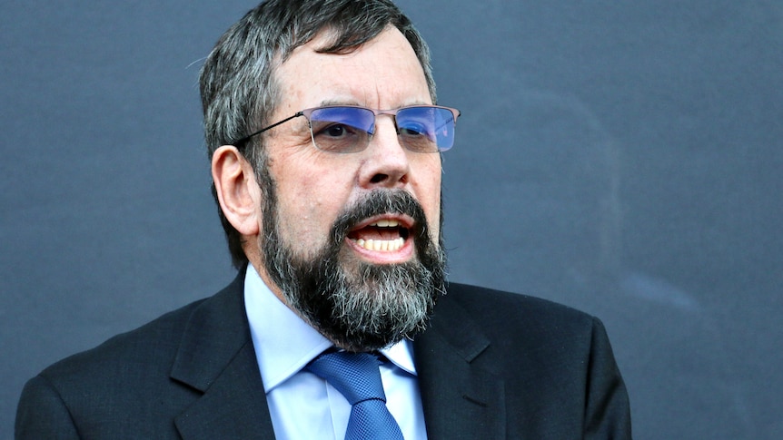 Headshot of a man wearing glasses.