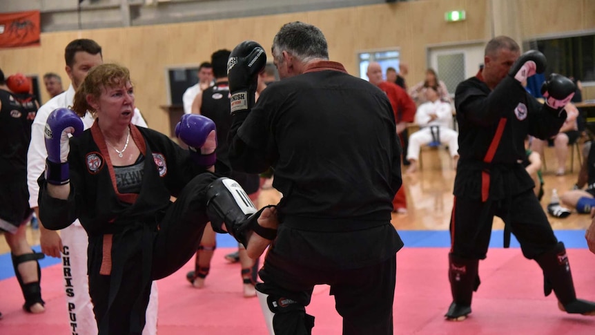 Zen Do Kai black belt Megan Pitts kicking her sparring partner, and husband, Damien Pitts.