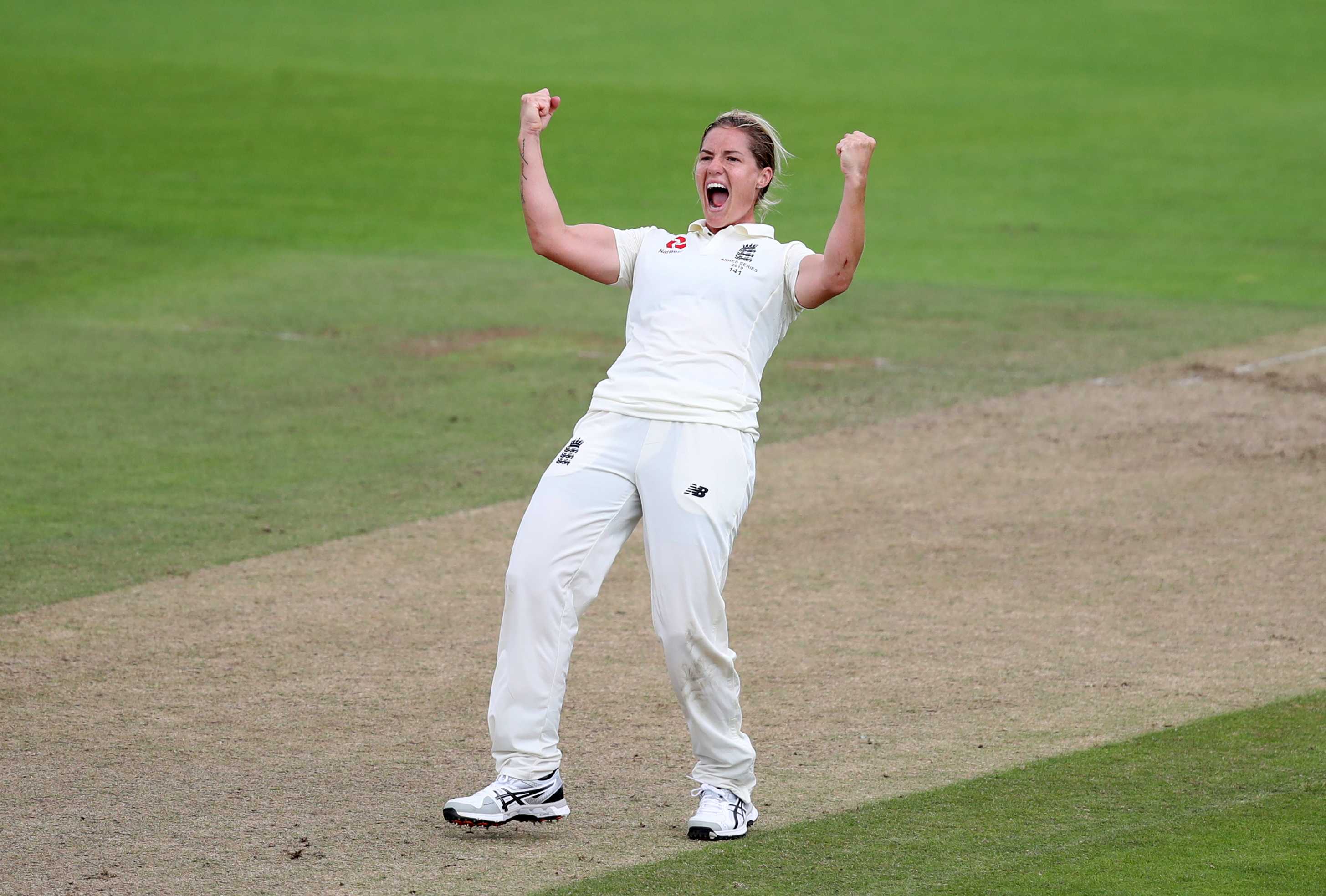 England bowler Katherine Brunt pumps both her fists in the middle of the pitch to celebrate taking a wicket.