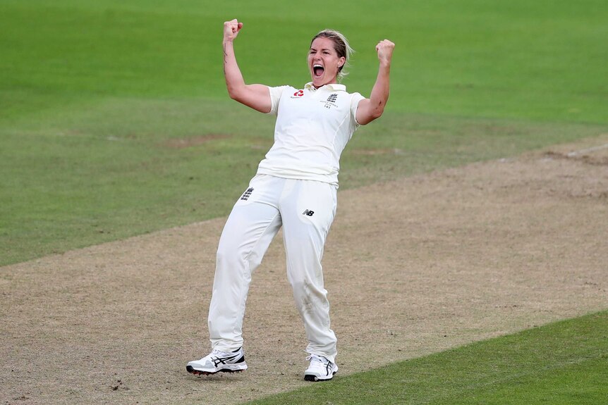 England bowler Katherine Brunt pumps both her fists in the middle of the pitch to celebrate taking a wicket.