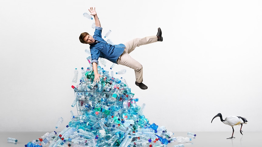 Craig Reucassel hovers above pile of plastic water bottles