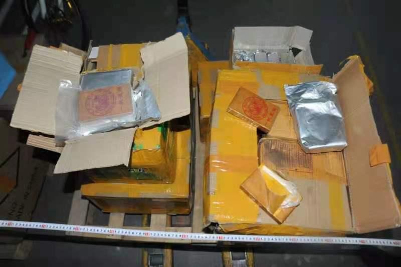 Packing boxes with yellow tape opened with silver packages inside and on top. 
