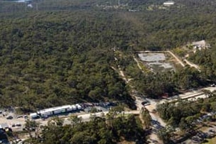 An aerial view of a coal mine, surrounded by trees.