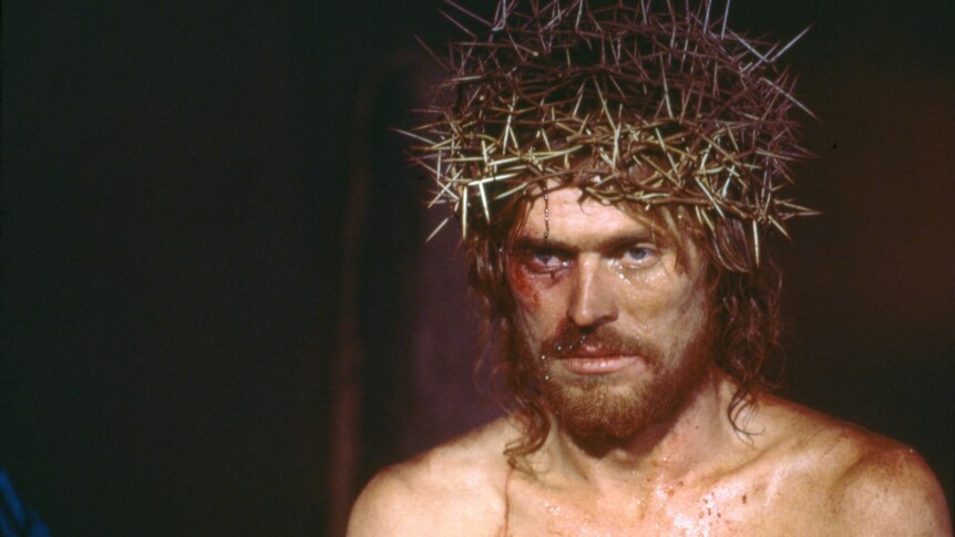 Willem Dafoe playing Jesus looking grim and beaten wearing the crown of thorns