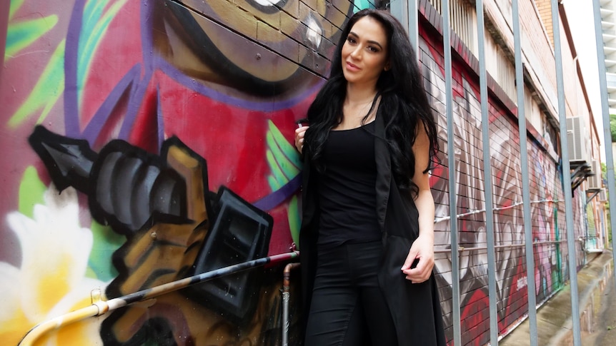 woman standing next to brick wall