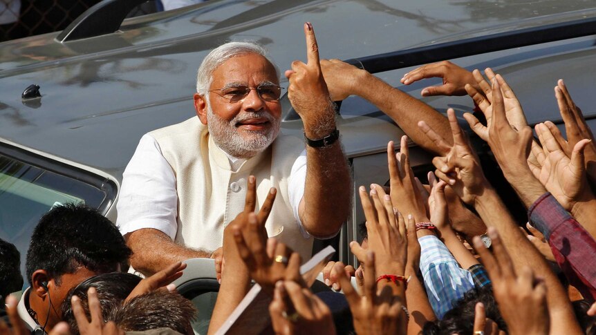 India prime ministerial candidate Narendra Modi shows his ink-marked finger to supporters