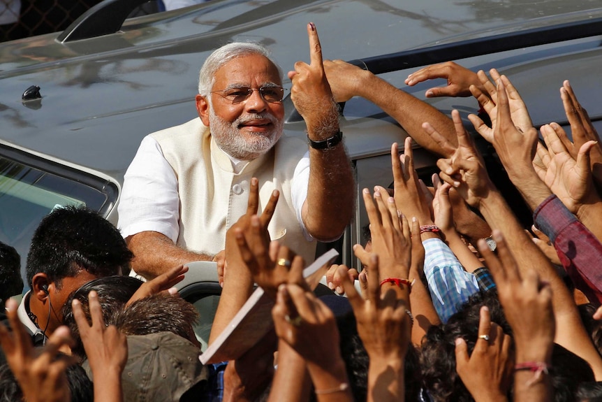 India prime ministerial candidate Narendra Modi shows his ink-marked finger to supporters