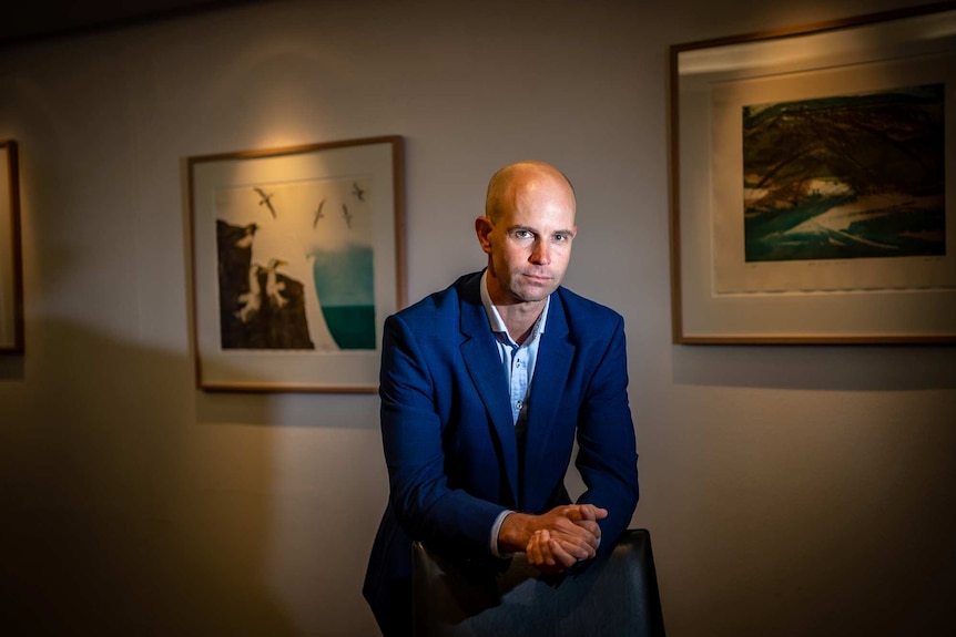 A bald man dressed in a suit in an office